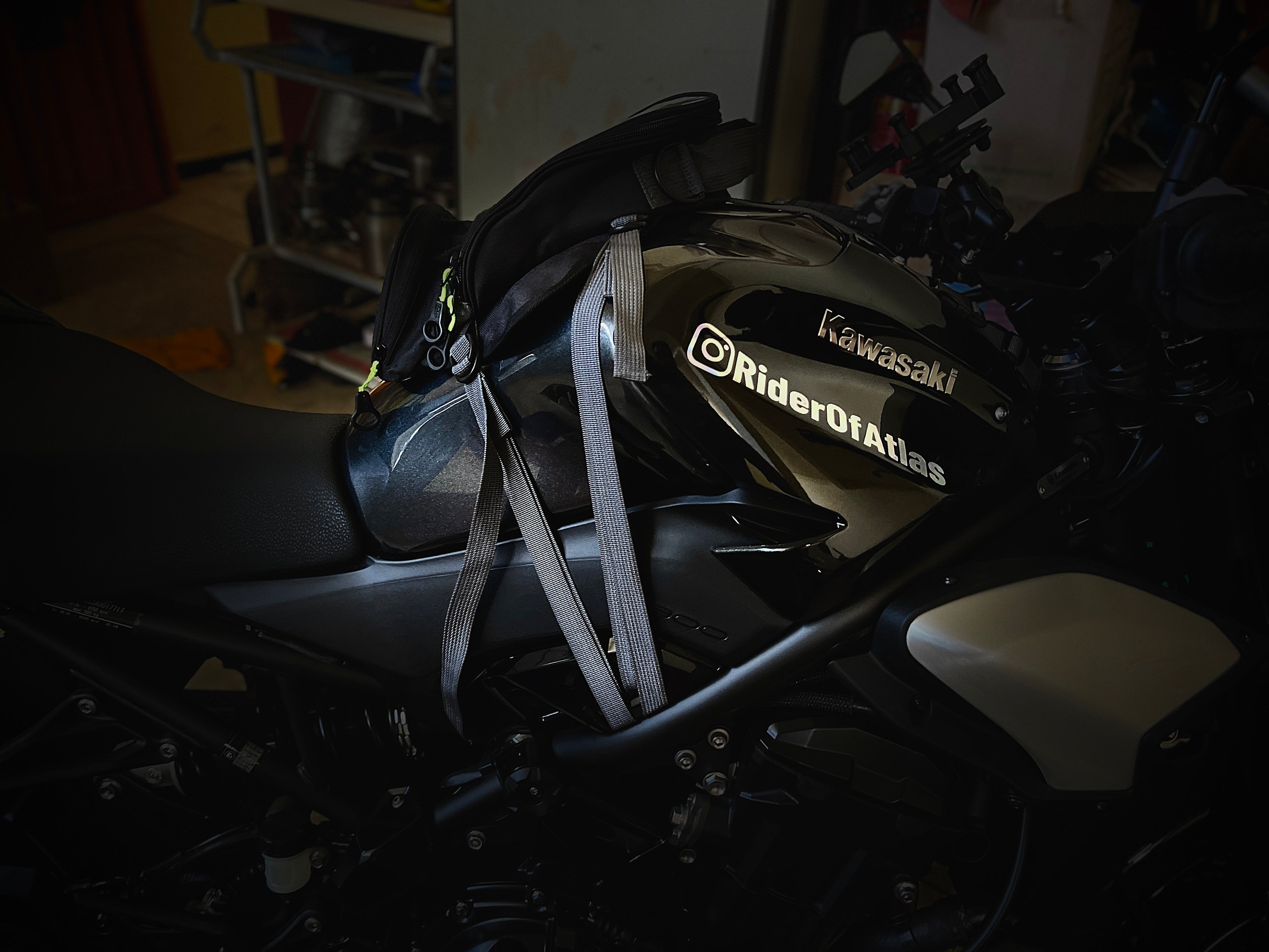 Kawasaki Z900 with 'RiderOfAtlas' branding on a motorcycle in a dimly lit room.